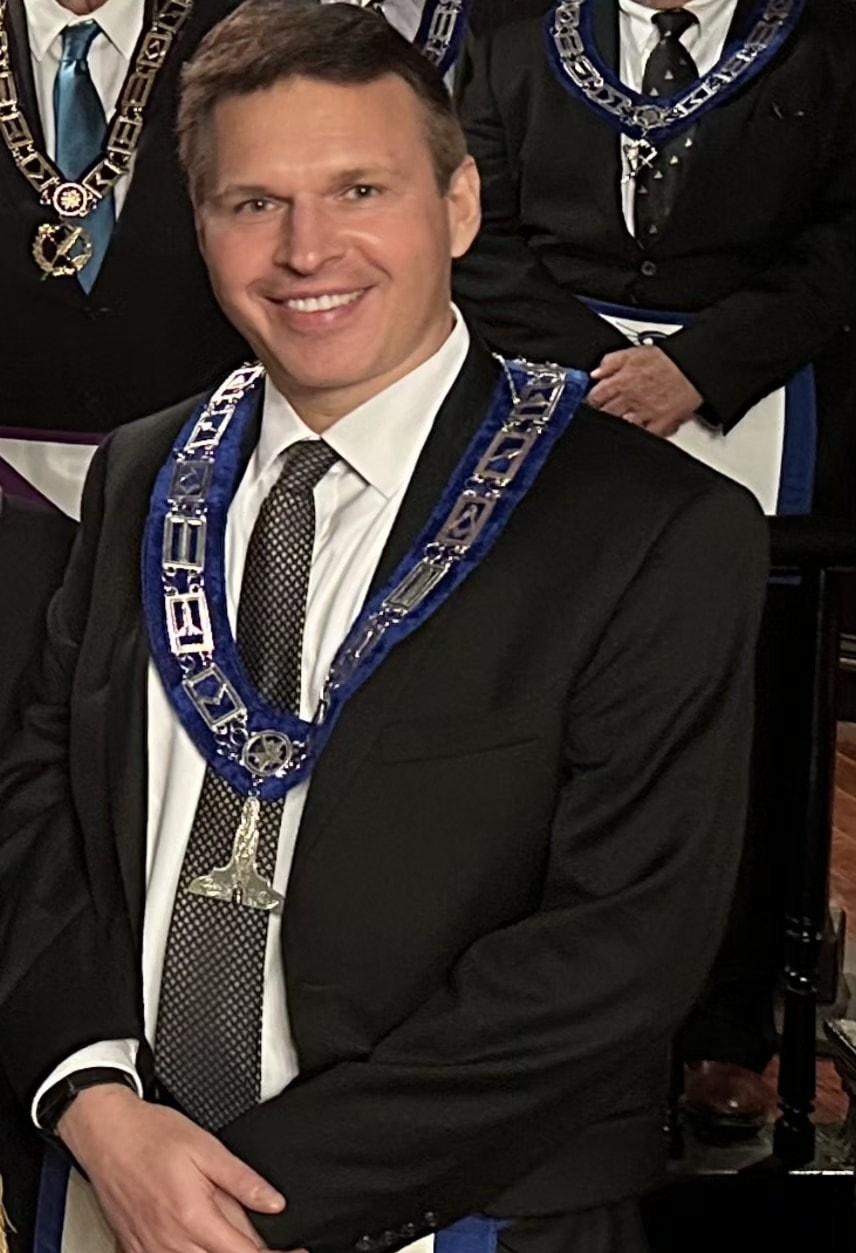 Brother in formal suit wearing Masonic collar and chain of office