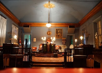 Interior of the Étoile Polaire Lodge hall with warm lighting and ceremonial furnishings
