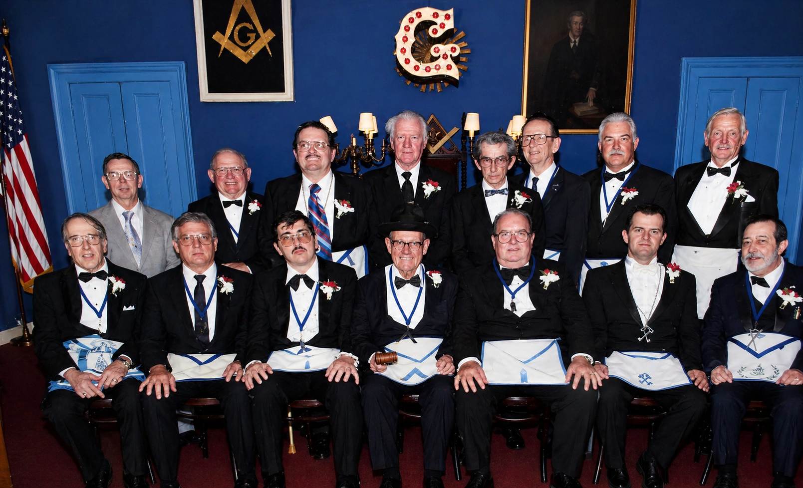 Lodge officers in tuxedos and blue Masonic aprons with chains of office posed in the blue lodge room, 1990s