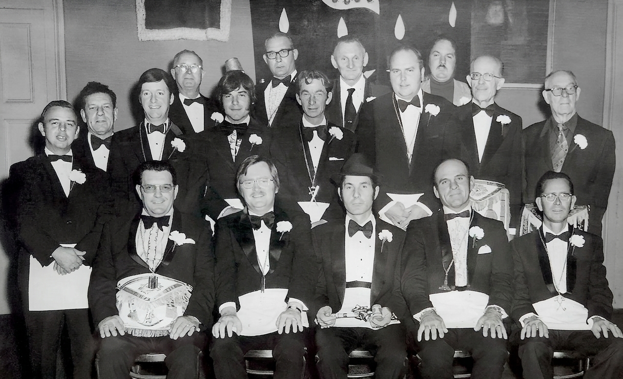 Lodge officers in tuxedos with white carnation boutonnieres and Masonic aprons, 1970s group portrait