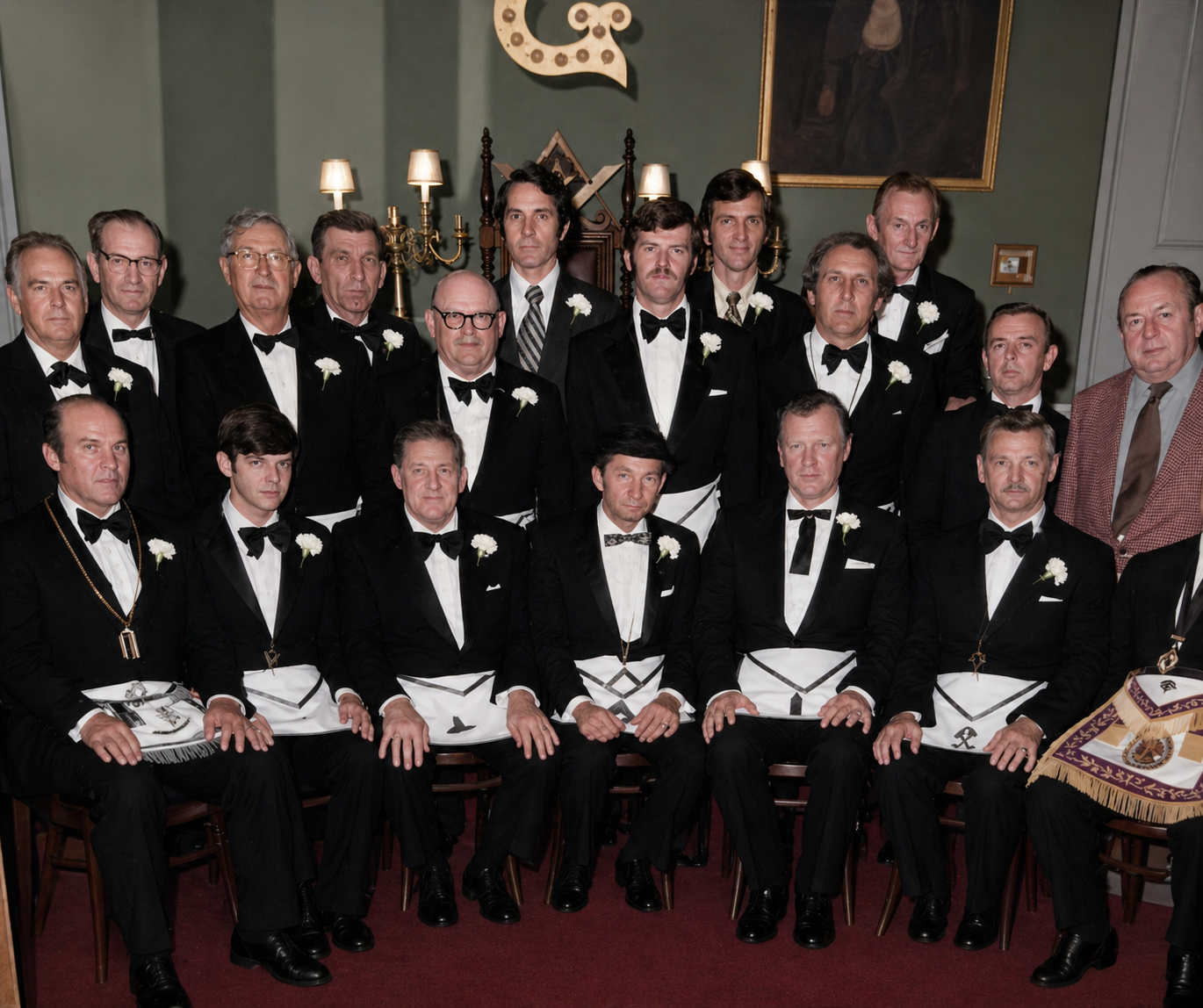 Large group of lodge officers in formal tuxedos and Masonic aprons posed in the lodge hall, 1970s