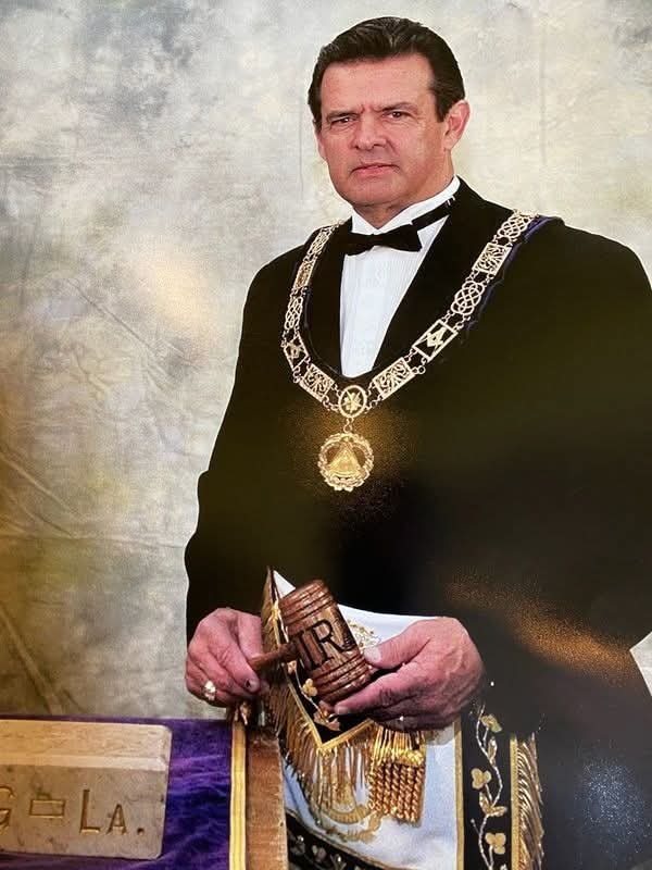 Worshipful Master in formal Masonic regalia with gavel and apron